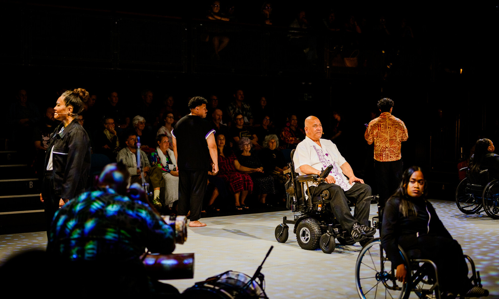 Performers, including wheelchair users, share the stage during a live theatre performance.